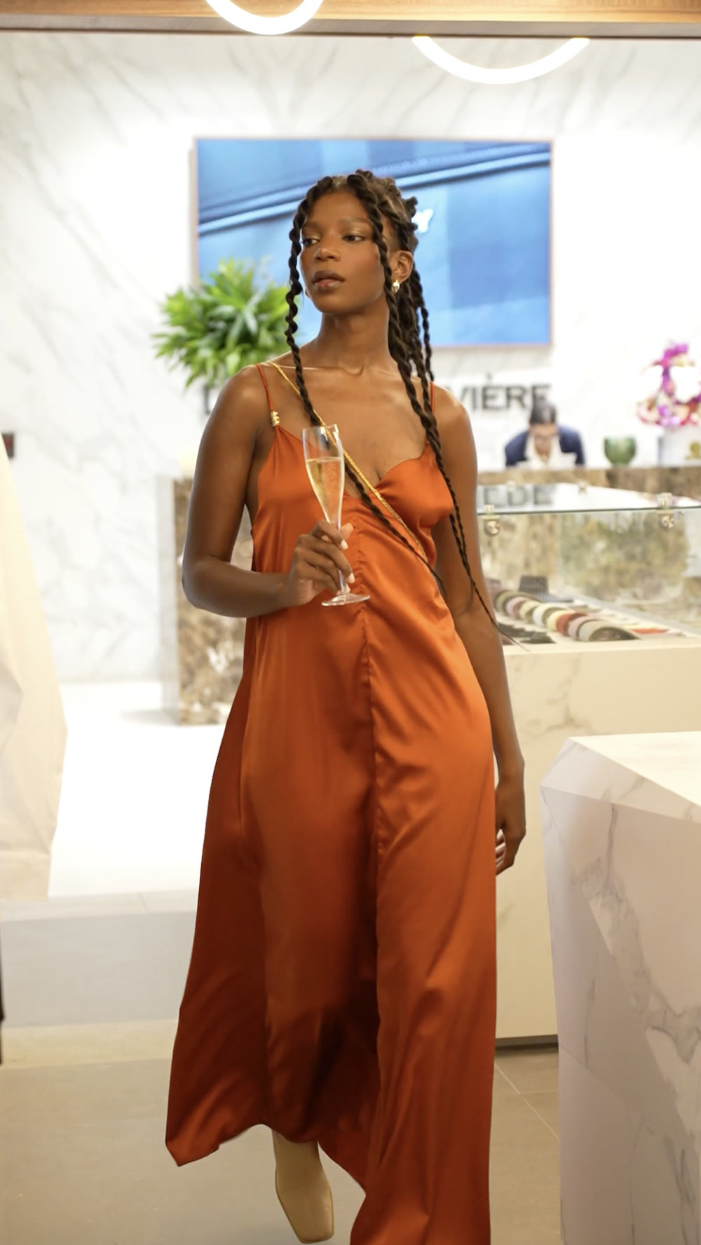 Fashion still: orange silk dress in a boutique